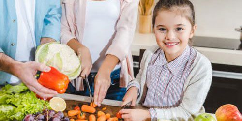 Como fazer as crianças comerem mais legumes e verduras Criança com legumes e verduras