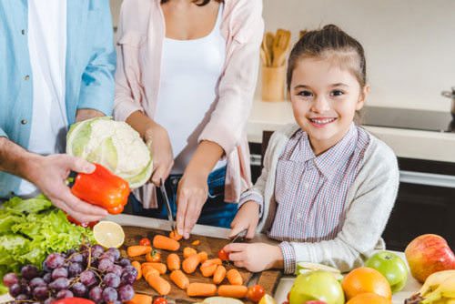Como fazer as crianças comerem mais legumes e verduras Criança com legumes e verduras