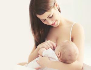 Mãe amamentando após uma dieta pós-parto para evitar cólicas no bebê.