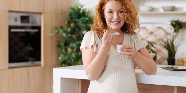 Benefícios do iogurte na gravidez Grávida consumindo iogurte natural