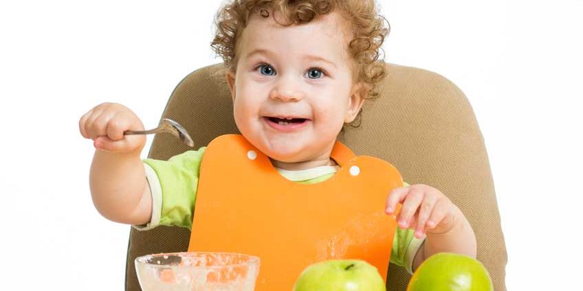 Menino comendo papinha de maça